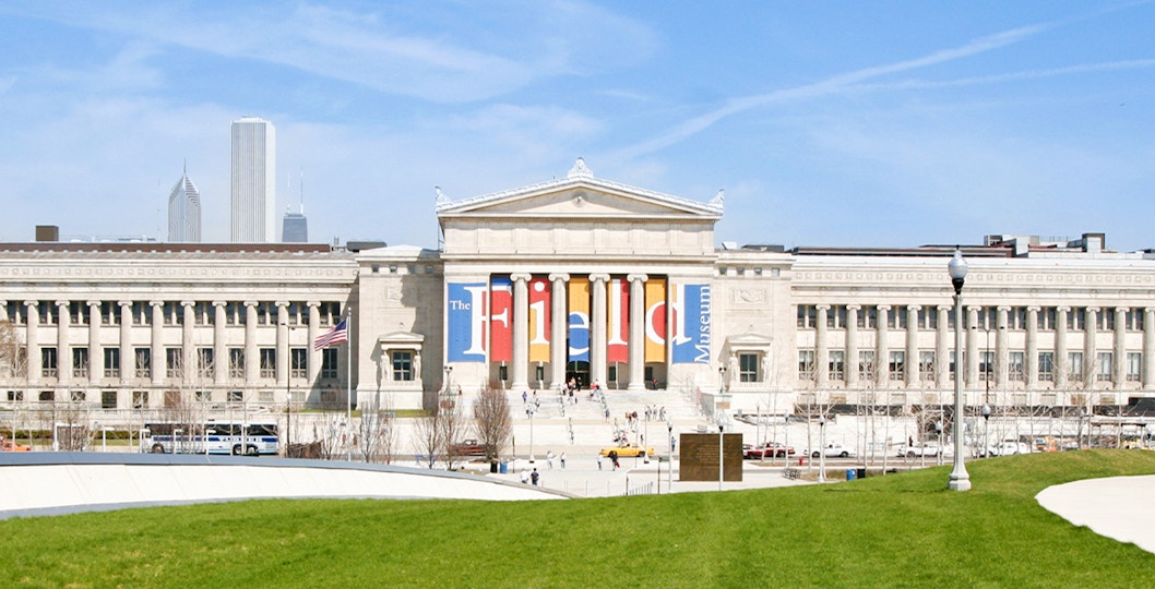 Field Museum of Natural History entrance in Chicago with city skyline in background.