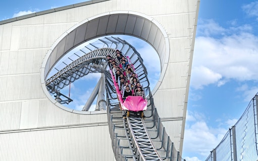 Roller coaster descending through a loop at Tokyo Dome.
