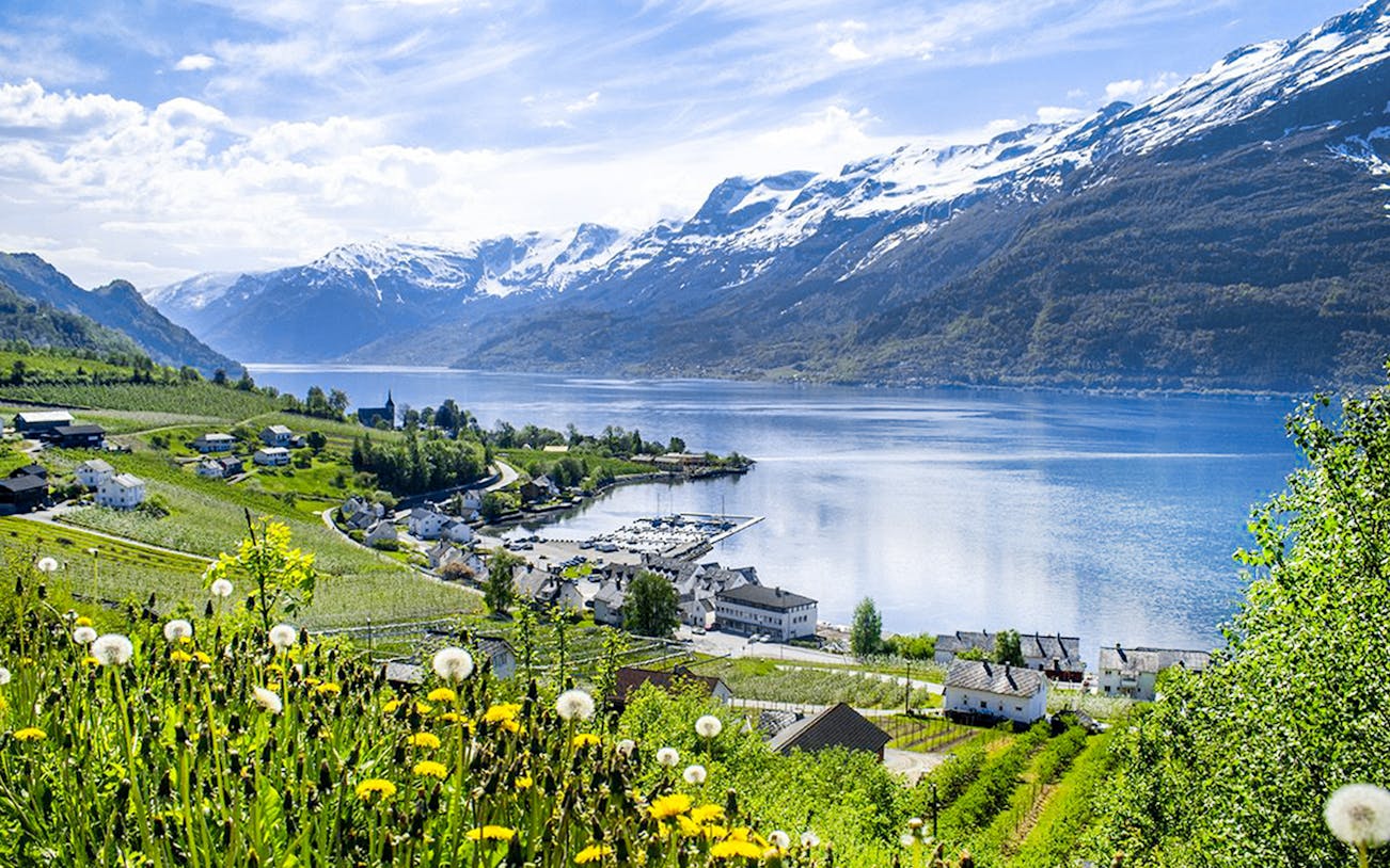 Hardangerfjord view with snow-capped mountains and village from a bus tour.
