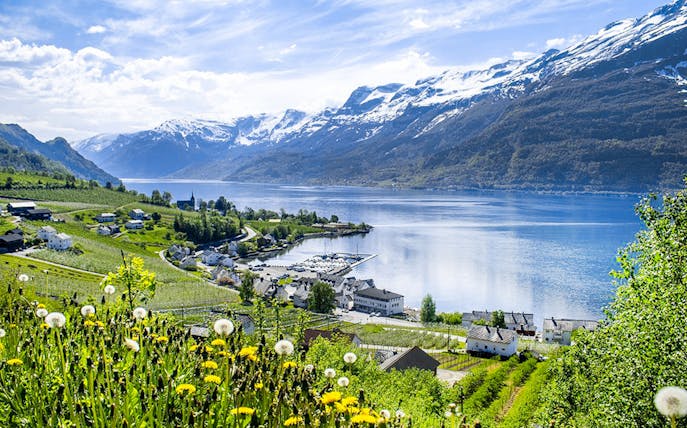 Hardangerfjord view with snow-capped mountains and village from a bus tour.