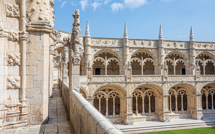 Jerónimos Monastery cloister with ornate arches and detailed stone carvings in Lisbon, Portugal.