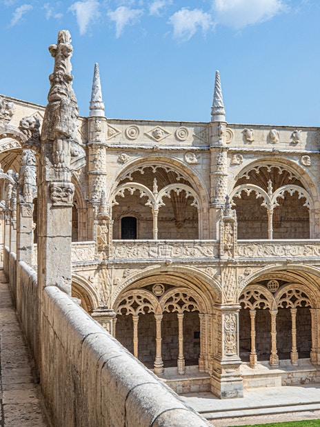 Jerónimos Monastery cloister with ornate arches and detailed stone carvings in Lisbon, Portugal.