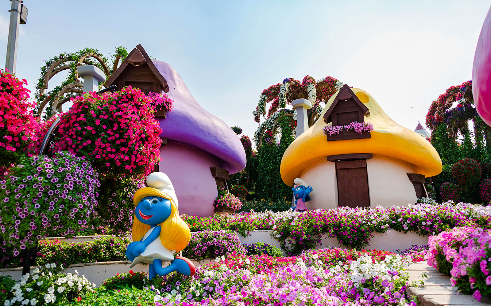 Smurfs Village at Miracle Garden with colorful mushroom houses and vibrant flowers.
