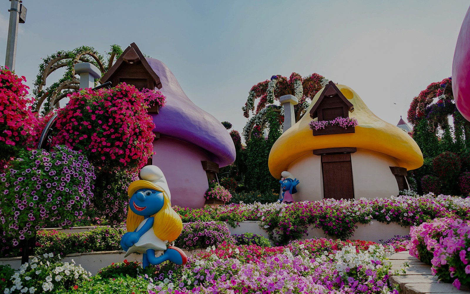Smurfs Village at Miracle Garden with colorful mushroom houses and vibrant flowers.