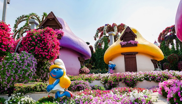 Smurfs Village at Miracle Garden with colorful mushroom houses and vibrant flowers.