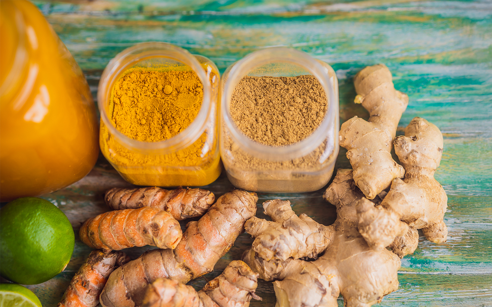 Traditional Balinese spices with turmeric, ginger, and lime on a wooden surface.