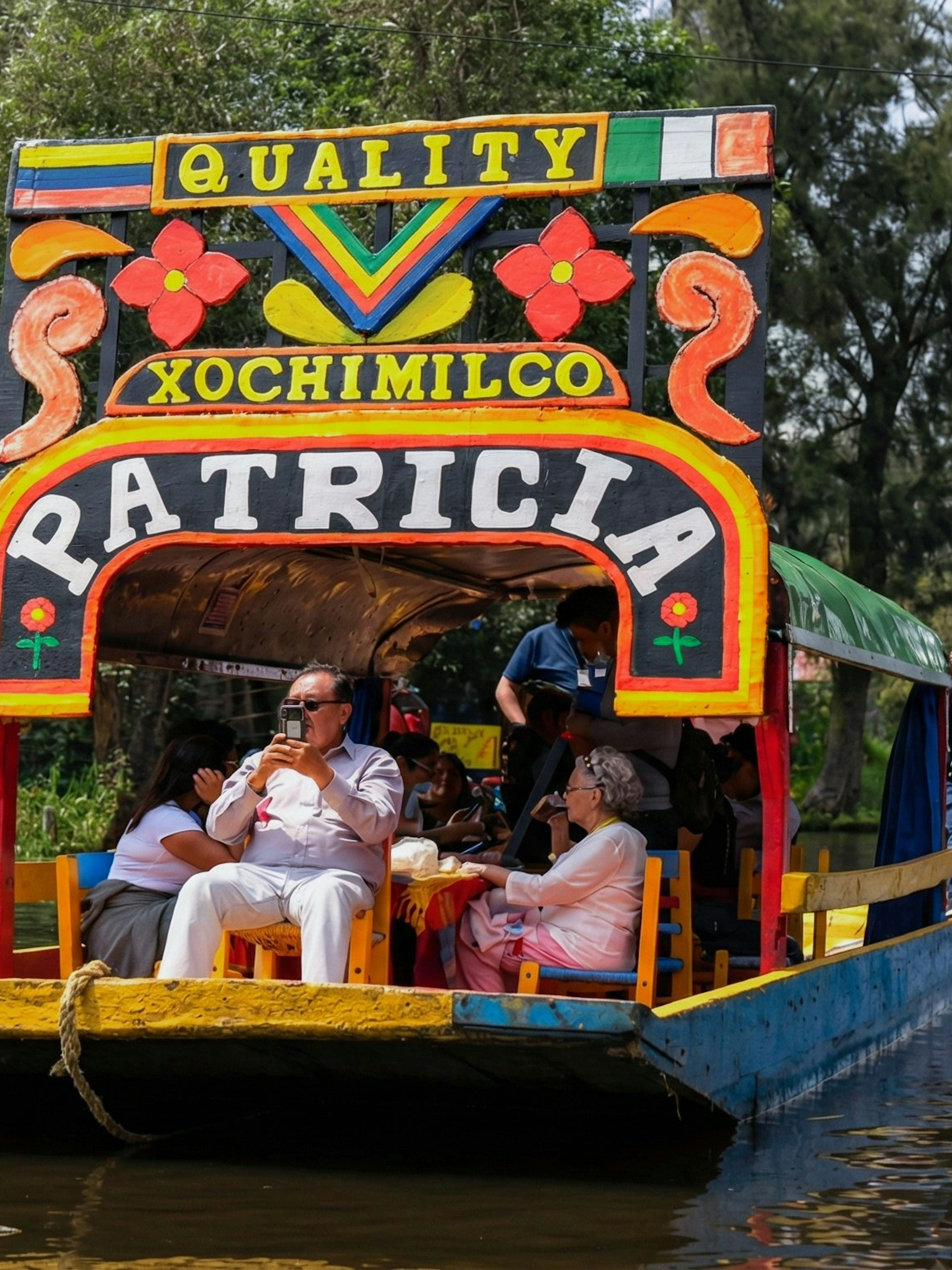 Xochimilco trajinera with tourists enjoying a canal ride in Mexico City.