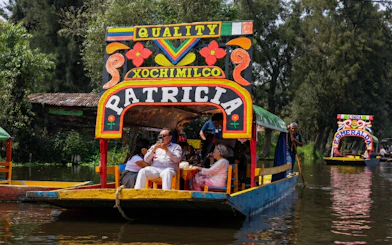Xochimilco trajinera with tourists enjoying a canal ride in Mexico City.