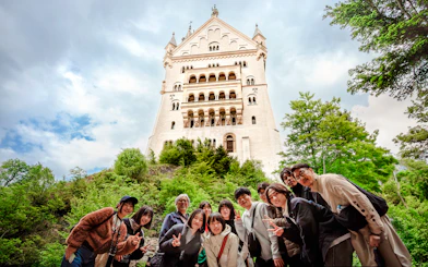 Tourists posing in front of Neuschwanstein Castle, Germany.
