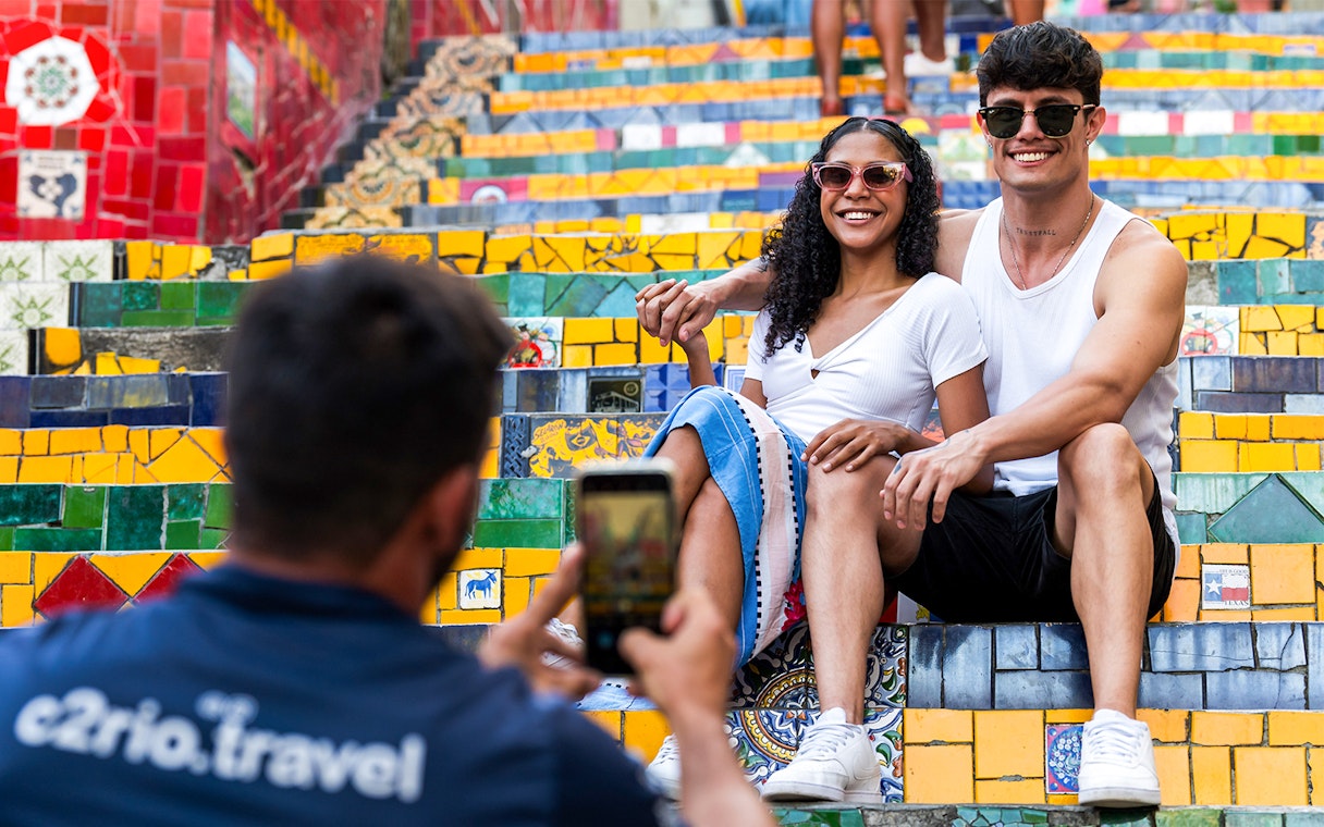 Couple posing on colorful Selarón Steps in Rio de Janeiro.