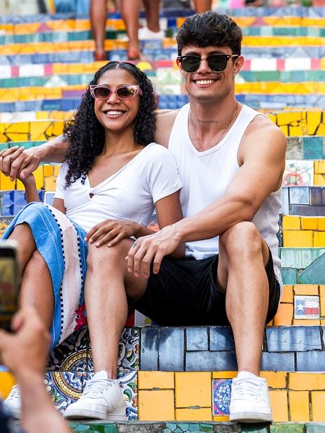 Couple posing on colorful Selarón Steps in Rio de Janeiro.