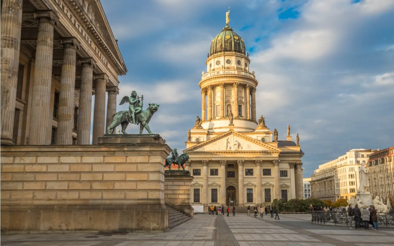 Gendarmenmarkt square with Berlin Cathedral and statue, part of self-guided city exploration game.