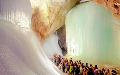 Visitors exploring Werfen Ice Caves, Salzburg, surrounded by large ice formations.