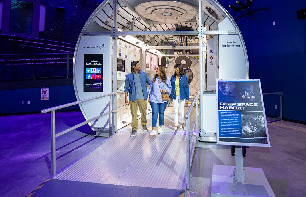 Visitors exploring a rocket exhibit at Kennedy Space Center, Orlando, with guided tour tickets.