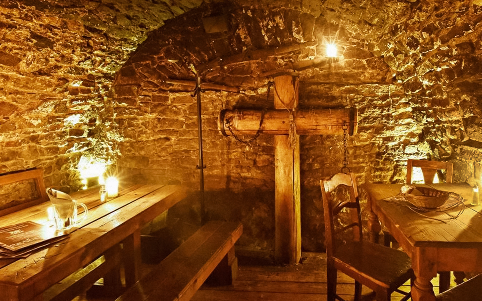 Medieval dining room in Prague with wooden tables and stone walls.