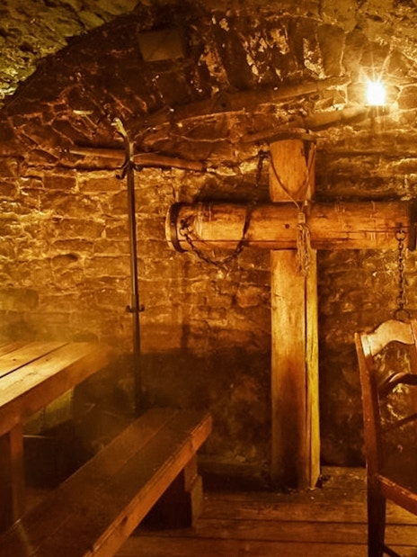 Medieval dining room in Prague with wooden tables and stone walls.