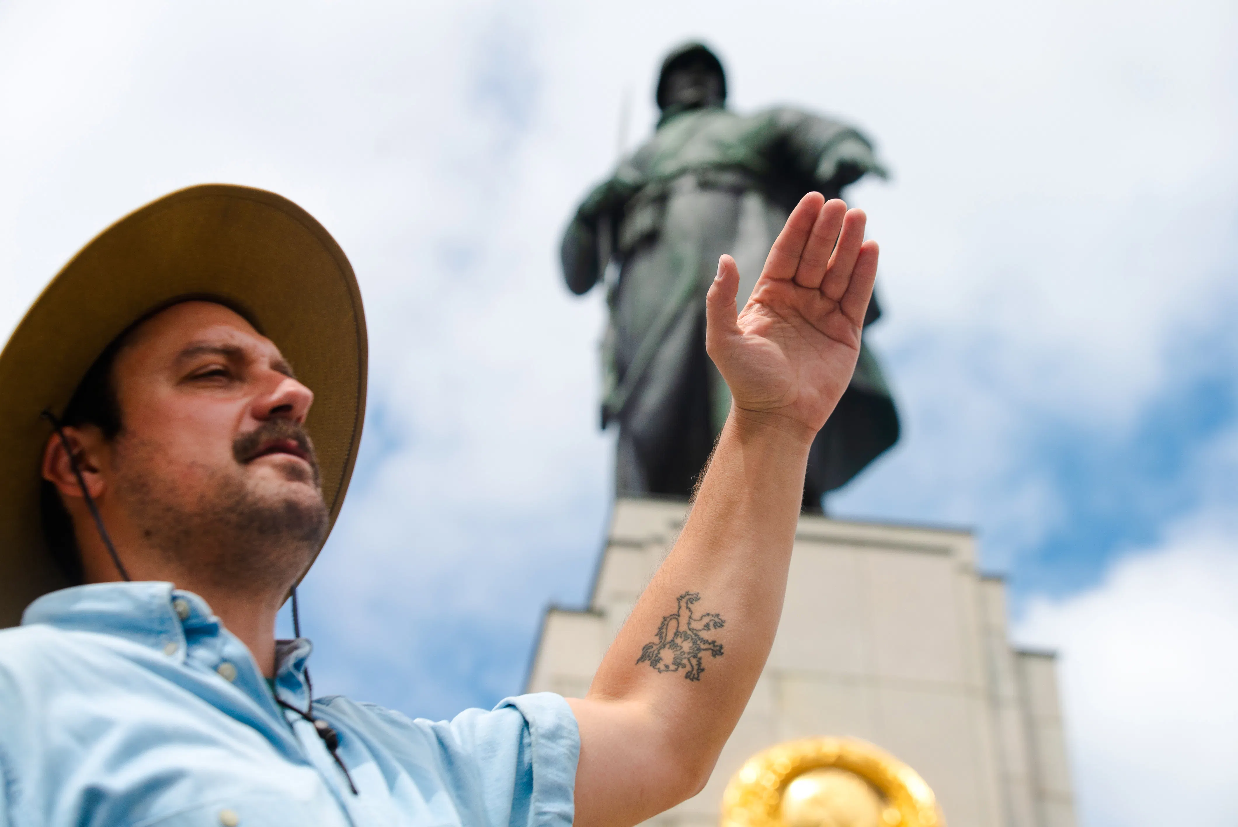 Tour guide gesturing near Soviet War Memorial in Berlin during Third Reich and Cold War walking tour.