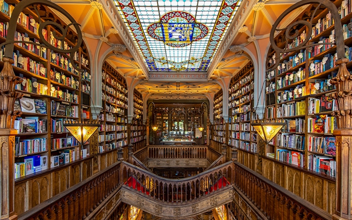 Lello Library interior with ornate wooden stairs and bookshelves, Porto, Portugal.