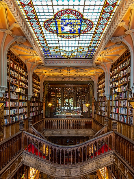 Lello Library interior with ornate wooden stairs and bookshelves, Porto, Portugal.