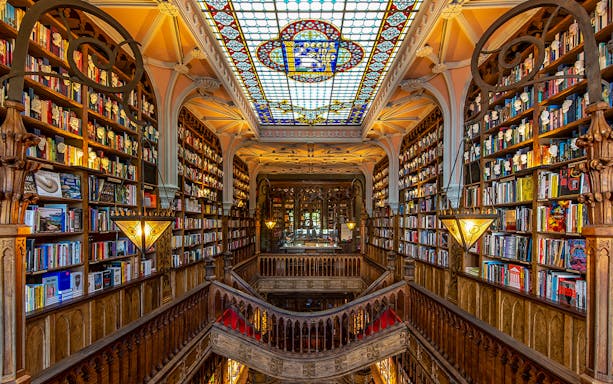 Lello Library interior with ornate wooden stairs and bookshelves, Porto, Portugal.