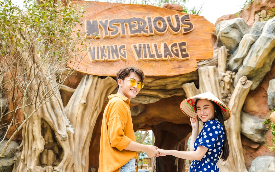 Tourists smiling at entrance of Mysterious Viking Village.