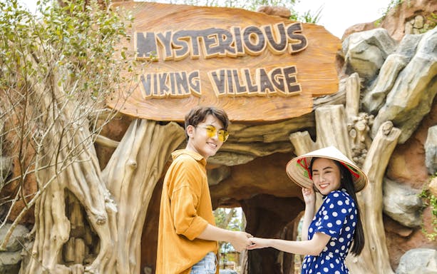 Tourists smiling at entrance of Mysterious Viking Village.