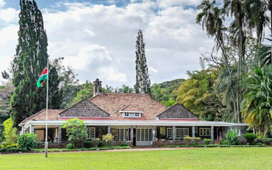 Karen Blixen Museum in Nairobi with lush gardens and Kenyan flag.