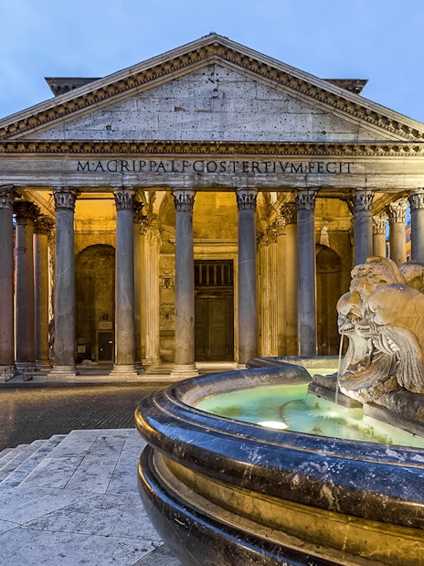 Pantheon in Rome with fountain in foreground at sunset.