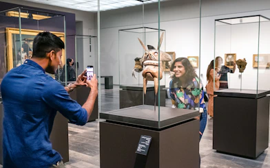 Visitors at Louvre Abu Dhabi viewing an artifact, part of a combo offer with National Aquarium tickets.
