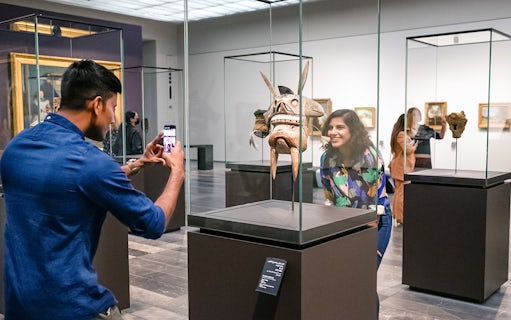 Visitors at Louvre Abu Dhabi viewing an artifact, part of a combo offer with National Aquarium tickets.