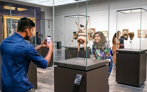 Visitors at Louvre Abu Dhabi viewing an artifact, part of a combo offer with National Aquarium tickets.