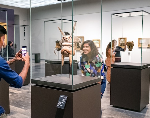 Visitors at Louvre Abu Dhabi viewing an artifact, part of a combo offer with National Aquarium tickets.