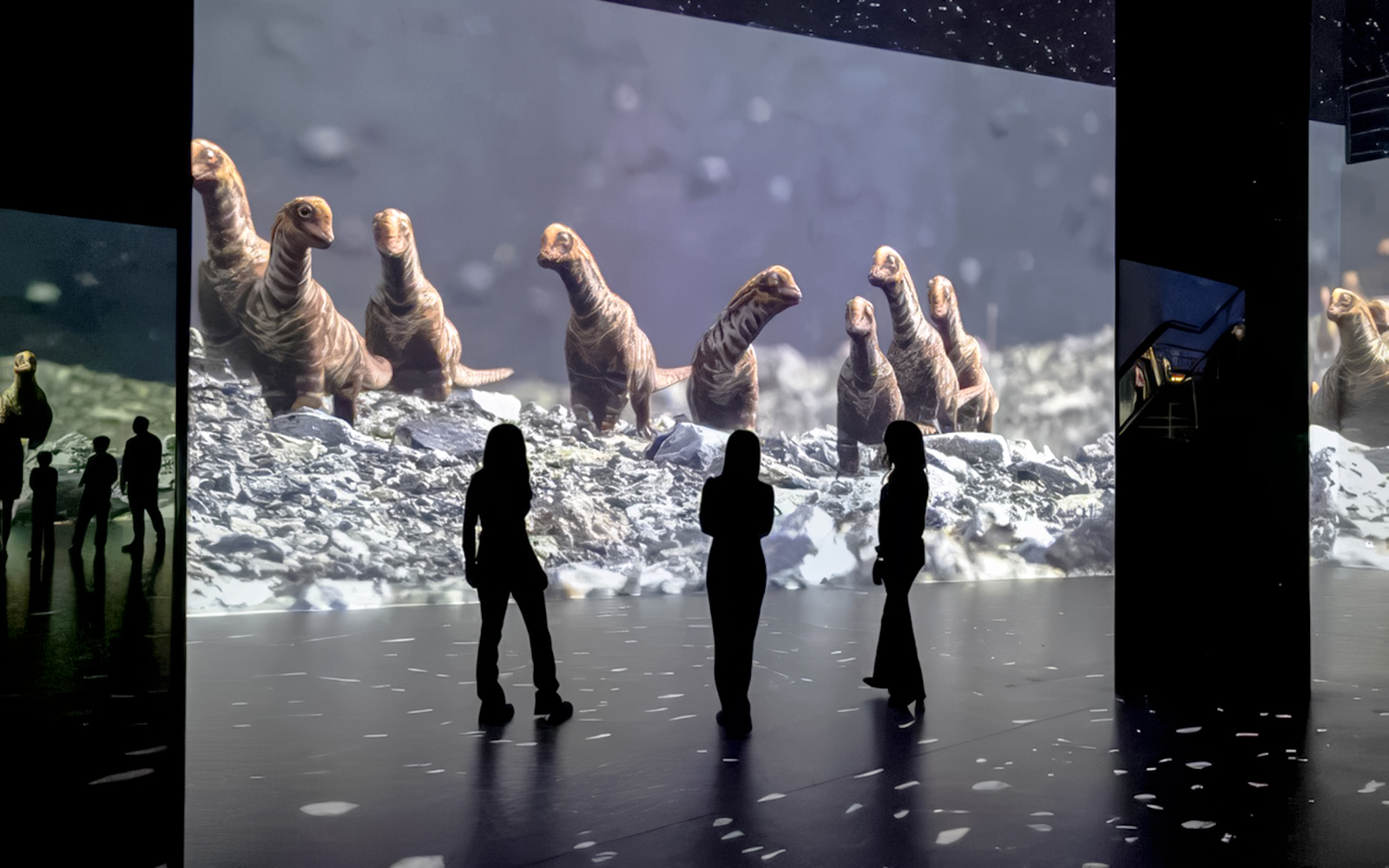 Guests viewing dinosaur projections at Phoenix des Lumières Dortmund exhibition.