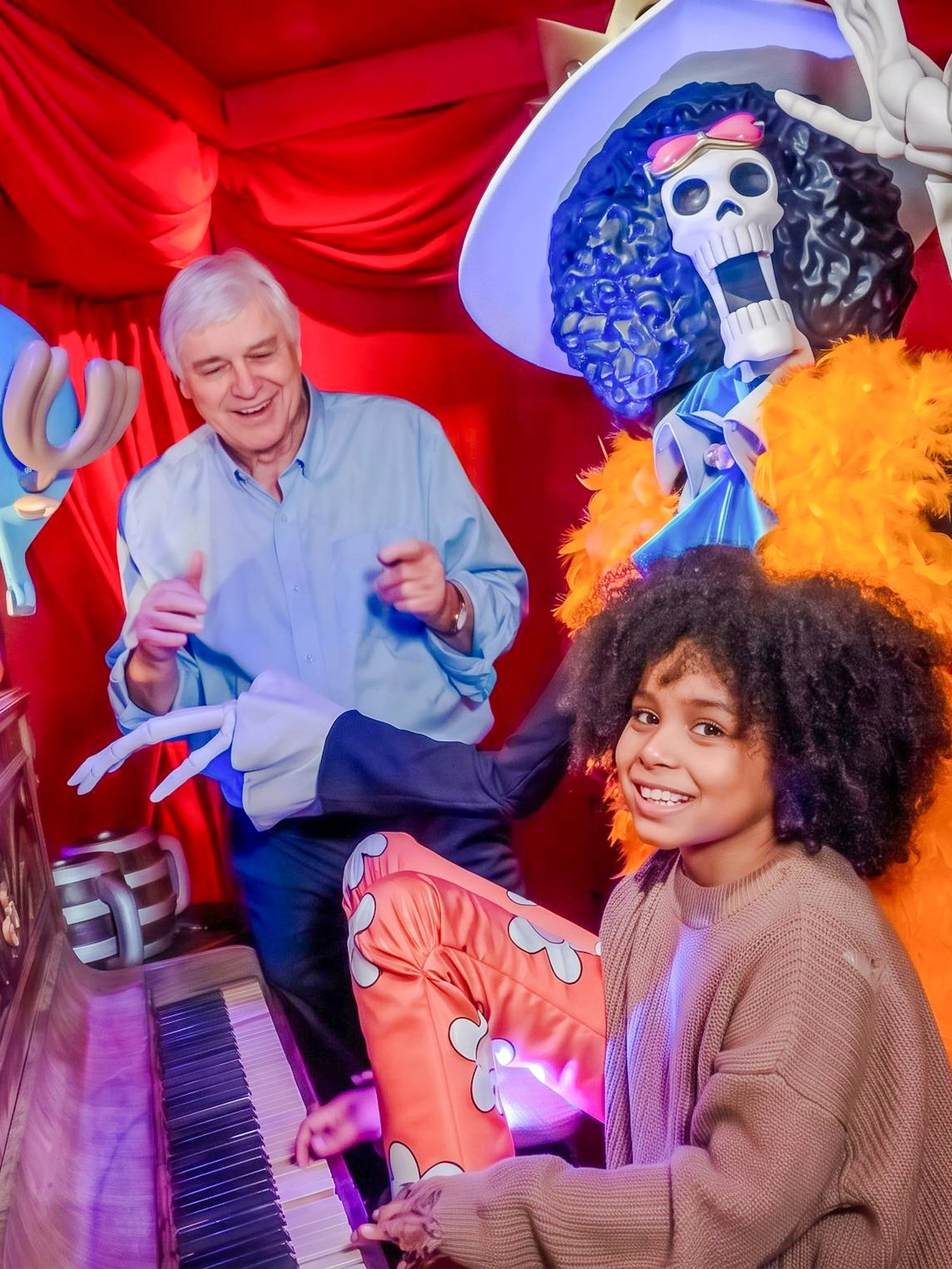 Child playing piano with wax figures at Grévin Paris Wax Museum.