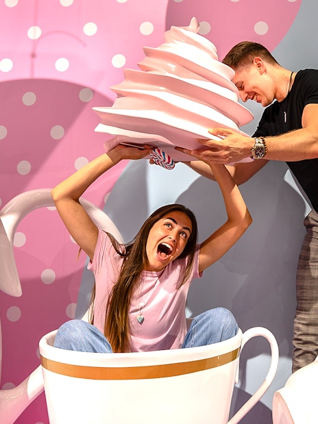 Guests enjoying giant cupcake prop at Museum of Candy, Dubai.