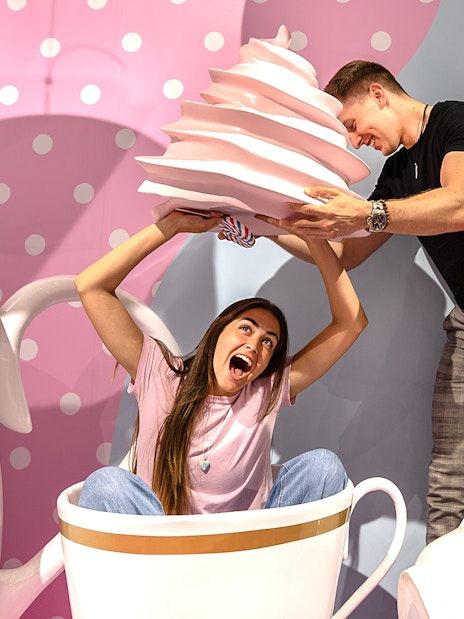 Guests enjoying giant cupcake prop at Museum of Candy, Dubai.