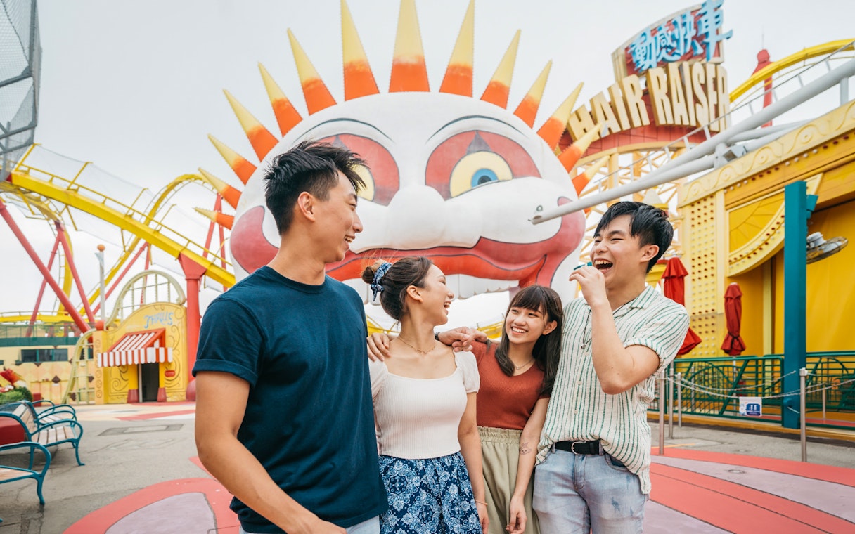 Friends laughing near the Hair Raiser ride at Ocean Park Theme Park.