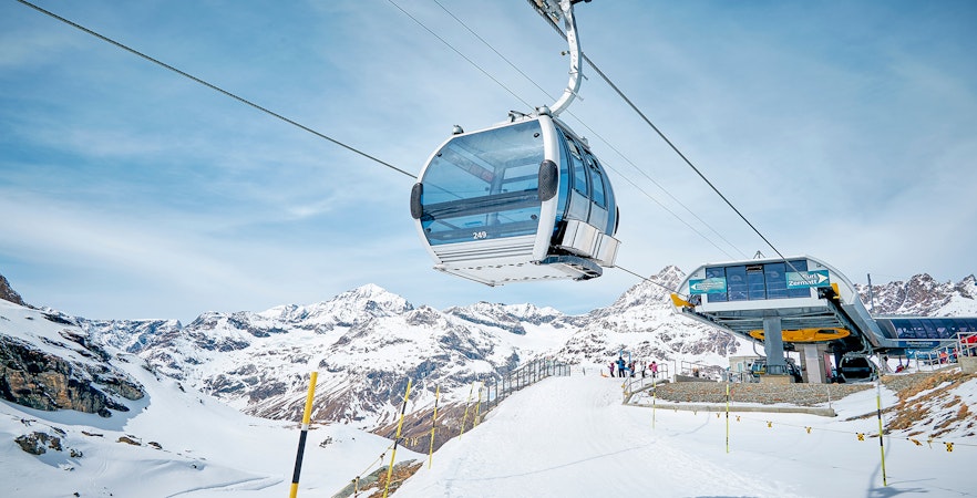 Cable car ascending to Matterhorn Glacier Paradise with snowy mountain backdrop.