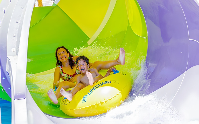 Family enjoying water slide at Aquopolis Villanueva de la Cañada Mini Waikiki Jungle.