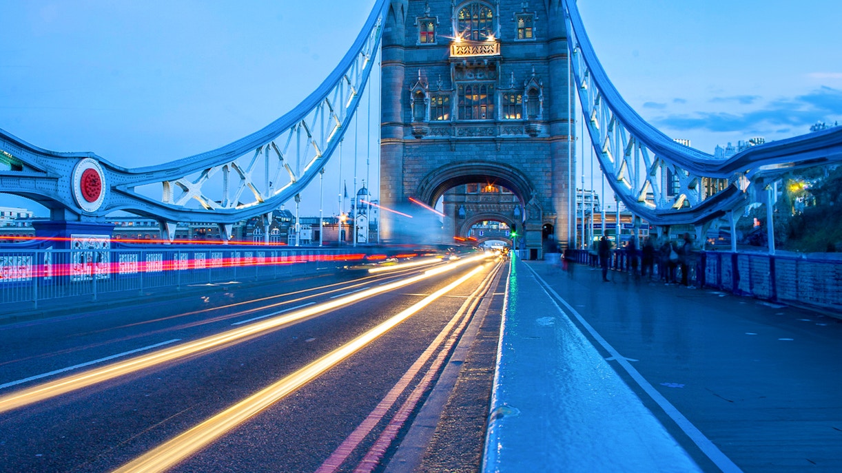 Tower Bridge in London illuminated at dusk with light trails from passing traffic.