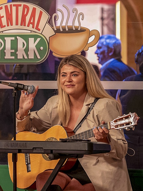 Musician playing guitar at Central Perk during the FRIENDS VIP Experience.