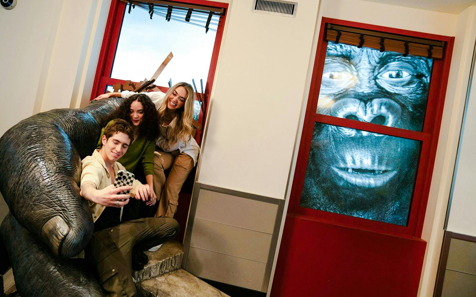 Visitors taking a selfie with a King Kong exhibit at the Empire State Building.