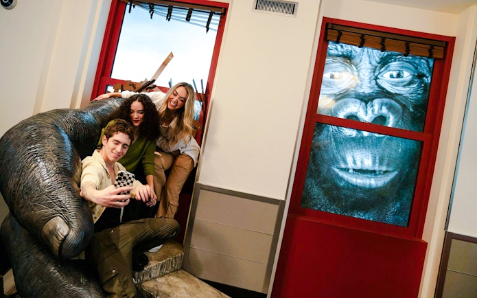 Visitors taking a selfie with a King Kong exhibit at the Empire State Building.