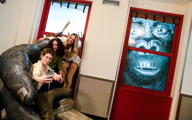 Visitors taking a selfie with a King Kong exhibit at the Empire State Building.