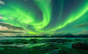 Northern Lights over Tromso fjord and mountains, Norway.