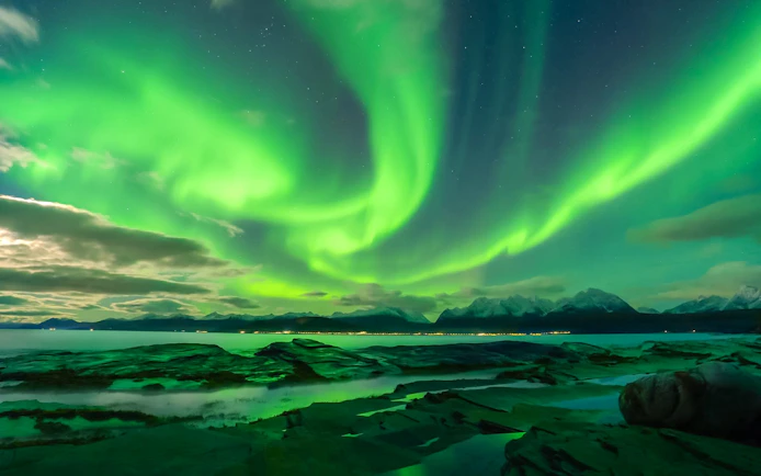 Northern Lights over Tromso fjord and mountains, Norway.