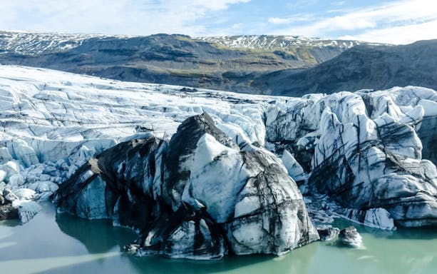 Sólheimajökull glacier with ice formations and surrounding landscape in Iceland.