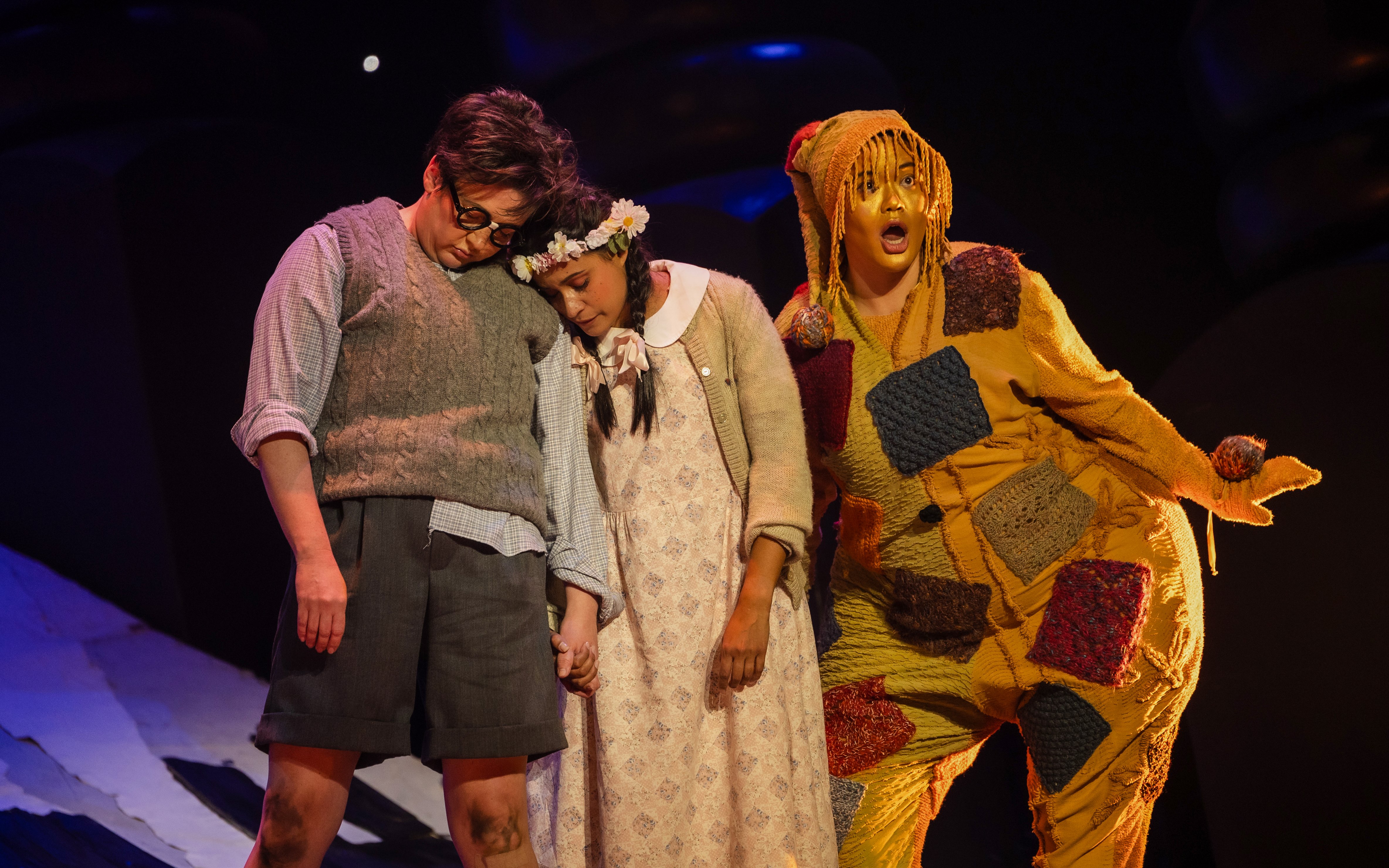 Actors performing Hansel and Gretel on stage, with colorful costumes and expressive poses.