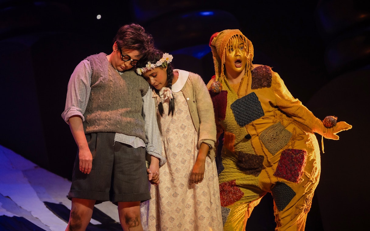 Actors performing Hansel and Gretel on stage, with colorful costumes and expressive poses.