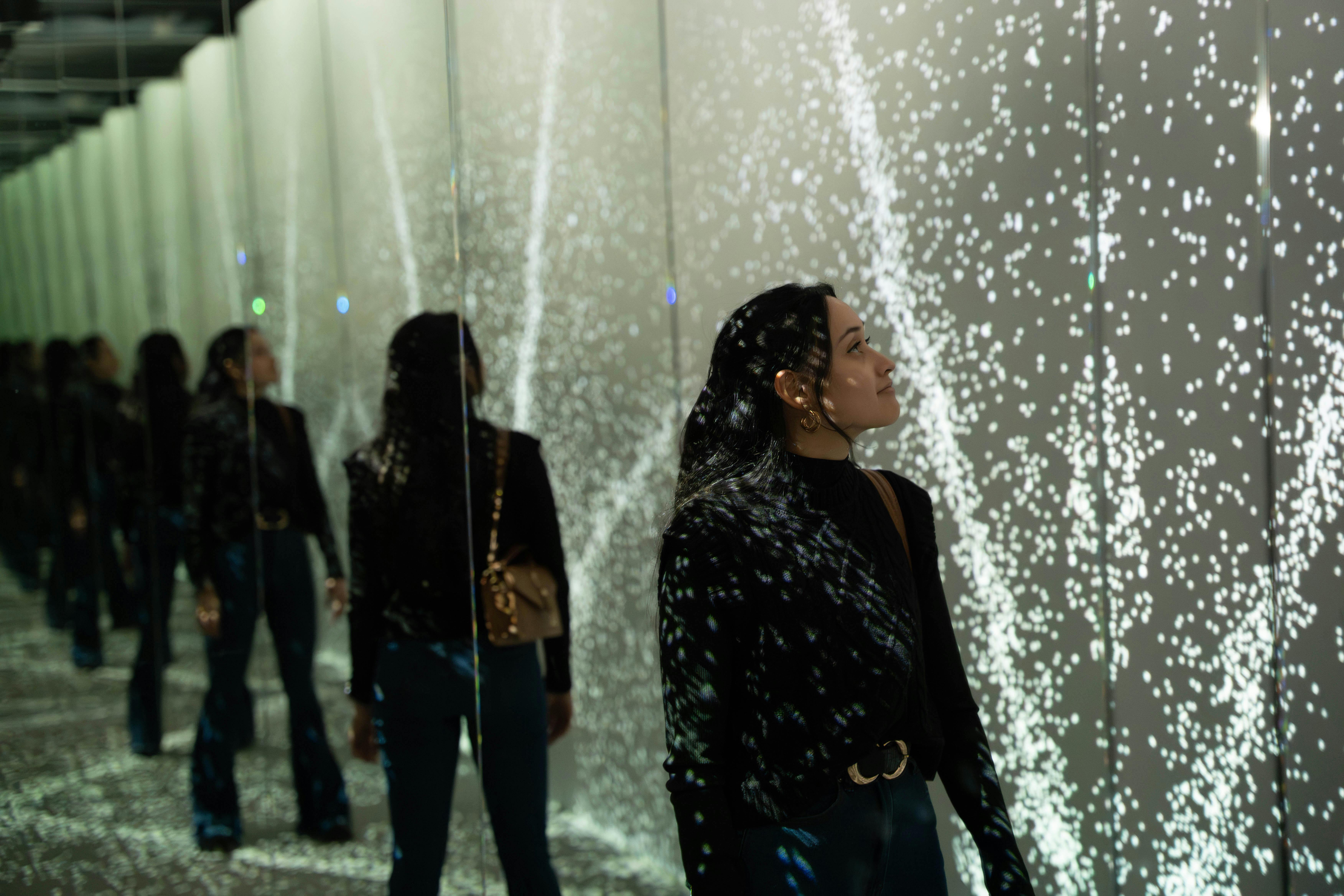 Guest exploring mirrored light display at World of Illusion, Dublin.